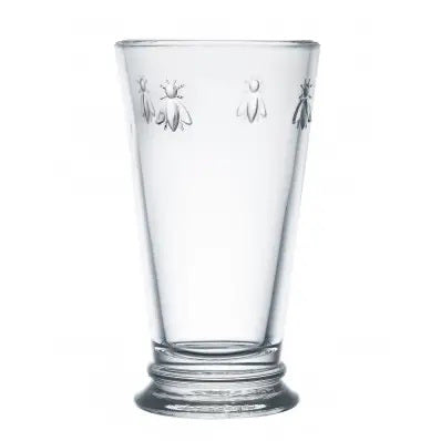 The BEE HIGHBALL GLASS by LA ROCHERE is a tall, clear glass with a flared shape and features an elegant pattern of engraved Napoleonic bees around the top edge, subtly enhancing its modern silhouette.