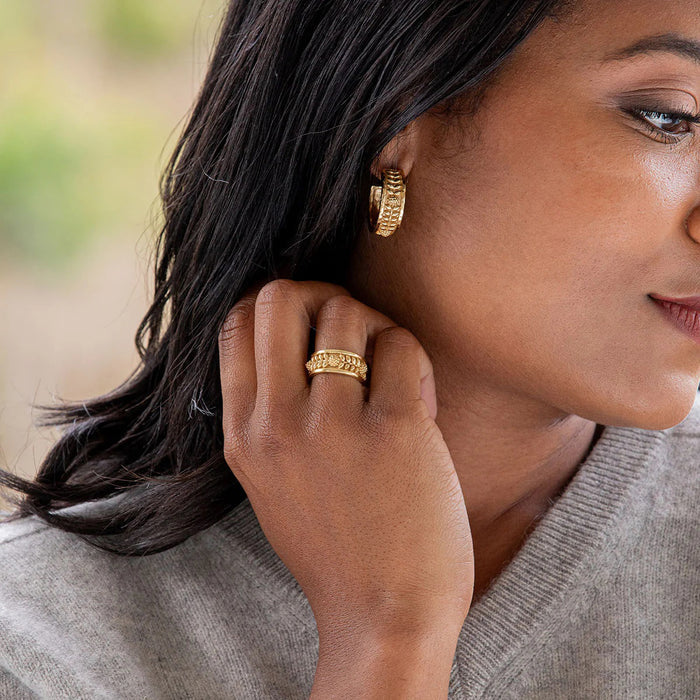 The CAPUCINE DE WULF Berry Vine Hoop Earrings feature an embossed floral and braided pattern in 18K gold, shown front and side on a white background to highlight their elegant, handcrafted design.