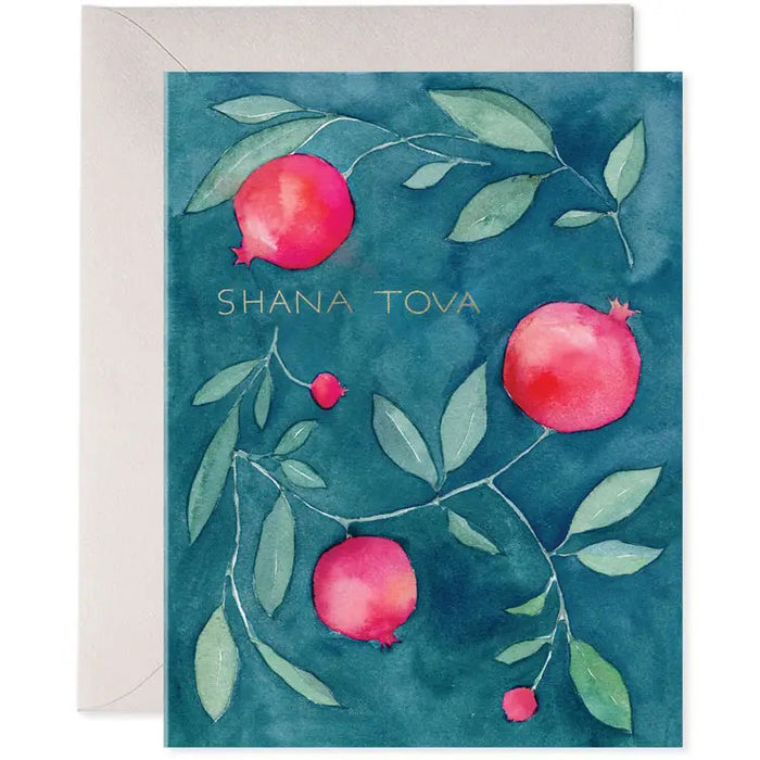 The E. FRANCES PAPER - SHANA TOVA CARD showcases a watercolor painting of pomegranates with leaves on a teal backdrop, elegantly embossed with gold foil "SHANA TOVA." A white envelope peeks out, suggesting the premium paper inside.