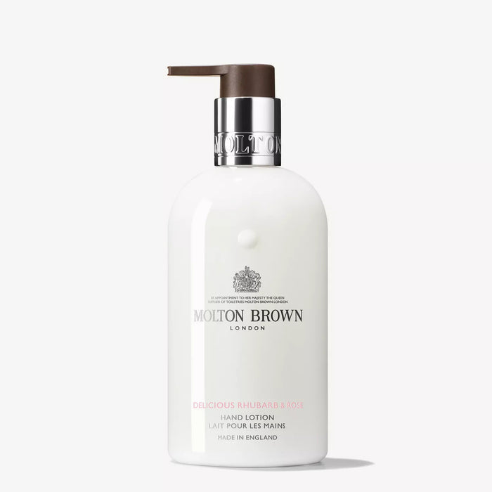 A white bottle of MOLTON BROWN - RHUBARB AND ROSE HAND LOTION with a brown pump and silver label stands upright on a white background—a floral-fruity moisturiser featuring an elegant rhubarb fragrance.