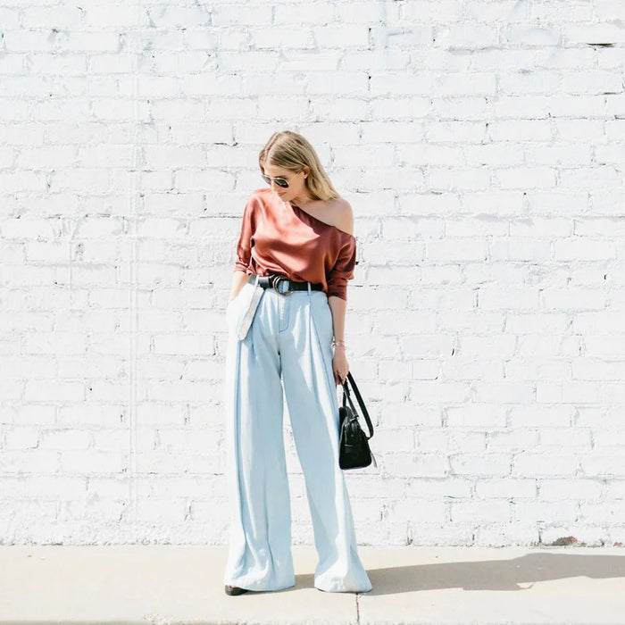 The ADA - JOSIE BELT by ADA is a brown leather belt featuring two overlapping brass rings as the buckle, displayed flat on a white background.