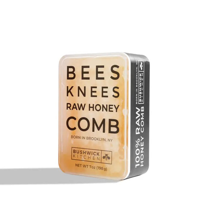 A rectangular container of BUSHWICK KITCHEN - 'BEES KNEES' RAW HONEYCOMB stands upright on a white background, featuring 100% raw honeycomb inspired by acacia honey and crafted in Brooklyn, NY.