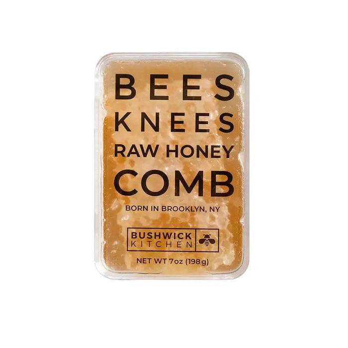 A rectangular container of BUSHWICK KITCHEN - 'BEES KNEES' RAW HONEYCOMB stands upright on a white background, featuring 100% raw honeycomb inspired by acacia honey and crafted in Brooklyn, NY.