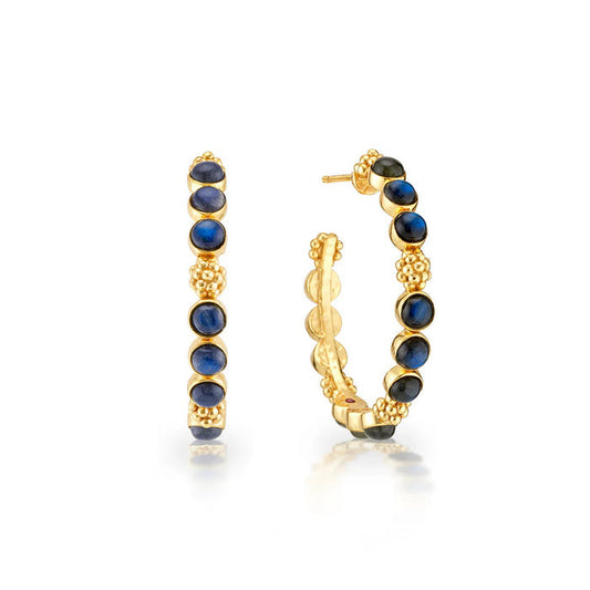 The CAPUCINE DE WULF Berry Gem Medium Blue Labradorite Earrings feature 18K gold hoops set with multiple round blue labradorite cabochons, each separated by gold beads, shown against a white background.