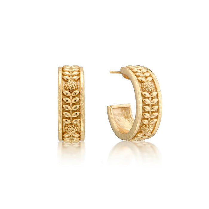 The CAPUCINE DE WULF Berry Vine Hoop Earrings feature an embossed floral and braided pattern in 18K gold, shown front and side on a white background to highlight their elegant, handcrafted design.