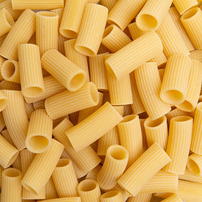 A turquoise and white CIPRIANI - ORGANIC RIGATONI PASTA package from ATALANTA CORPORATION stands upright on a white background, with a window showing rigatoni made from durum wheat semolina and Italian text on the front.