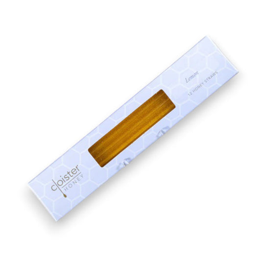 A white box from Cloister Honey, featuring a hexagonal pattern, displays Lemon Honey Straws made from natural honey, visible through a rectangular window.