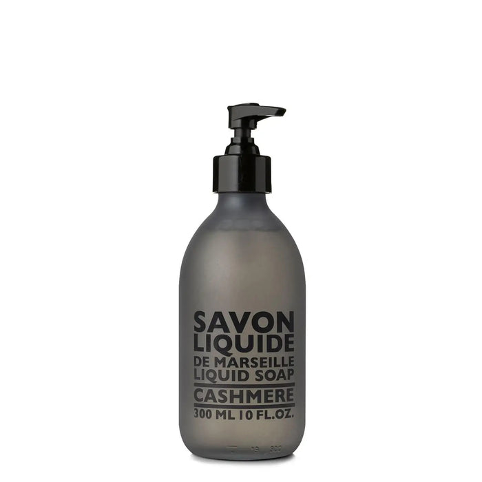 A frosted grey pump bottle of COMPAGNIE DE PROVENCE's Savon Liquide De Marseille Cashmere Soap by CIE LUXE BRANDS features a black dispenser and contains 300 ml (10 fl. oz.) of soap infused with luxurious botanical oils.