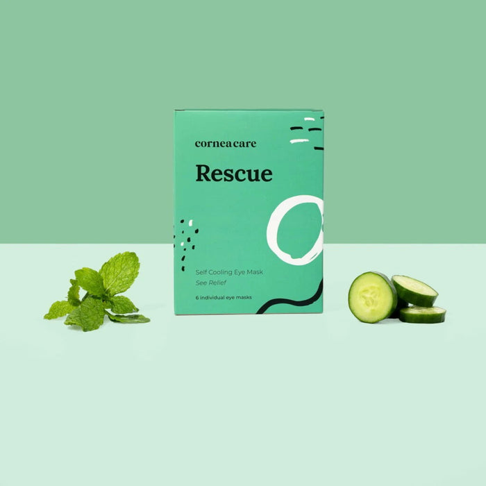 A white pouch with green designs reading "CORNEACARE - RESCUE SELF COOLING EYE MASK" by CORNEA CARE is shown next to a light blue, under-eye shaped mask. It offers soothing relief for eye care and dry eyes. The backdrop is plain white.