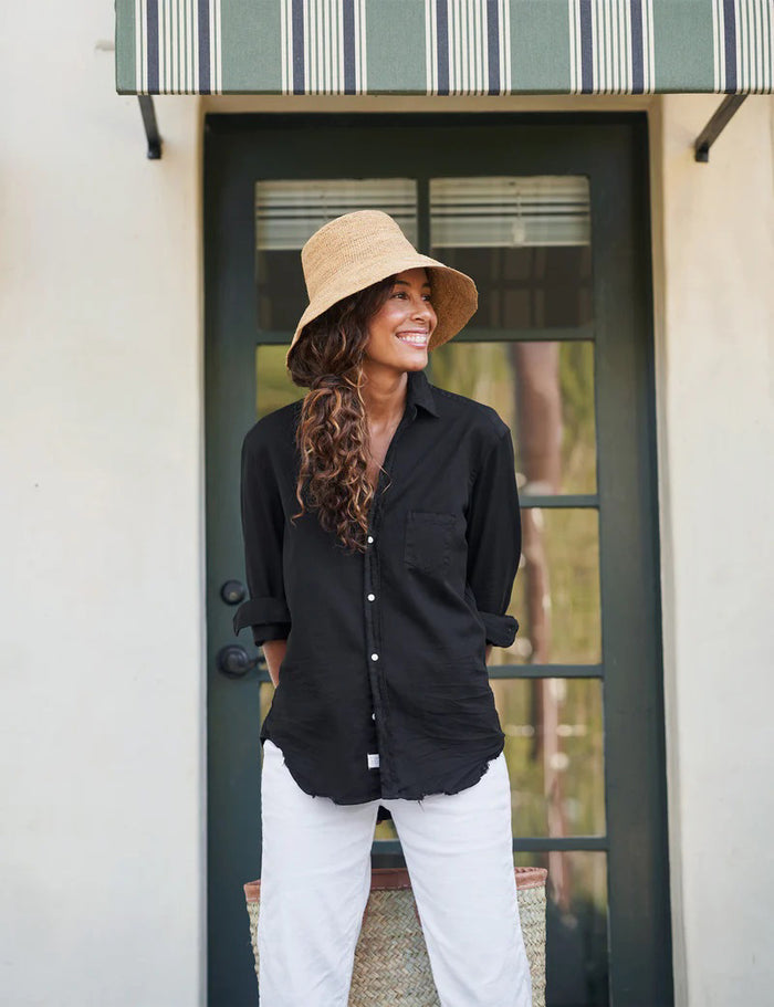 The FRANK & EILEEN Eileen Relaxed Button-Up in Black Tattered Denim provides a relaxed fit with long sleeves that can be stylishly rolled up. It includes a single breast pocket on the left side and features a slightly curved hem, complemented by bust-enhancing button placement for added elegance.