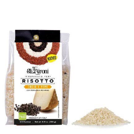A package of Zia Pia Imports' GLI AIRONI - CACIO E PEPPE RISOTTO sits next to uncooked carnaroli rice, with packaging featuring cheese, peppercorns, and bilingual Italian-English text.
