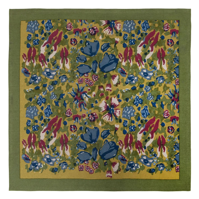 A stack of folded JARDIN BLUE & VERT CLOTH NAPKINs tied with a "COULEUR NATURE" ribbon features a top napkin with blue and red floral patterns on green from the Jardin Collection, while the bottom napkins are solid green.