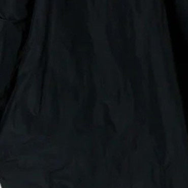 A close-up of a black fabric, likely part of KATHARINA HOVMAN's Cropped Pant in Taffeta. The smooth texture with subtle wrinkles suggests lightweight material, perfect for casual 3/4-length pants featuring an elastic waistband.