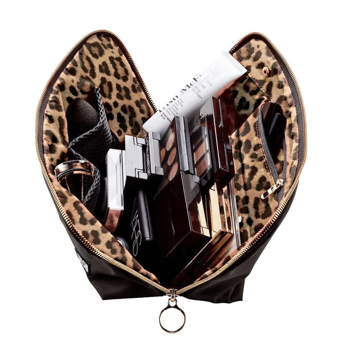 The KUSSHI - SIGNATURE MAKEUP BAG IN BLACK features a gold zipper and a small rectangular white and black "KUSSHI" logo patch on the lower right corner, displayed against a white background.
