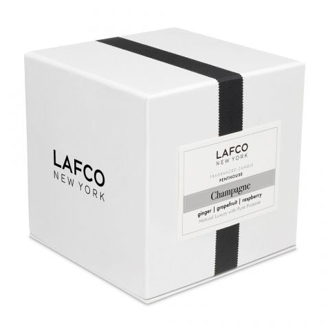 The LAFCO Champagne Penthouse 6.5oz candle, set in a clear glass holder on a white background, evokes calm and sophistication—like savoring fresh notes of orange in an elegant penthouse setting.