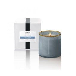 The LAFCO - SEA DUNE, BEACH HOUSE 6.5OZ features a clear glass tumbler with grey-tinted sides and a gold rim, its thick base casting a soft shadow to the right on a white background.