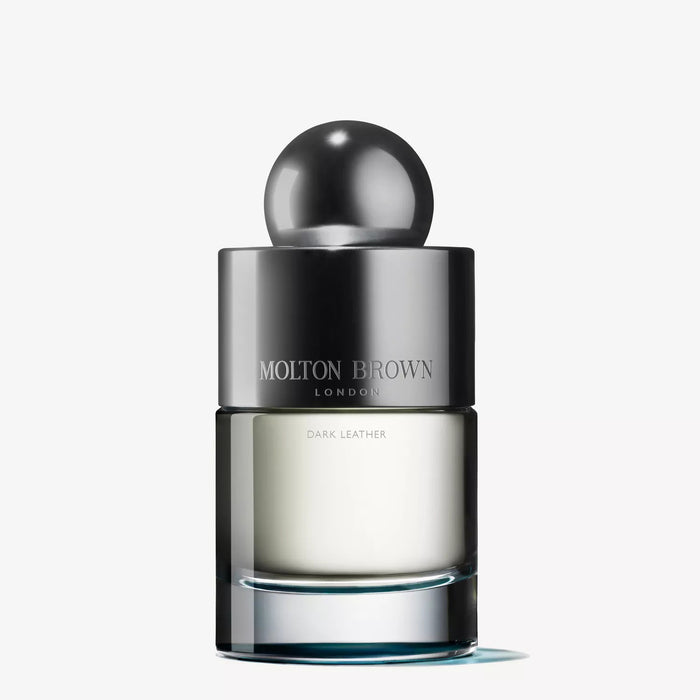 The MOLTON BROWN - DARK LEATHER EAU DE TOILETTE 100ML features a metallic cap and clear glass bottle with pale liquid, offering a smoky leather scent against a white background.