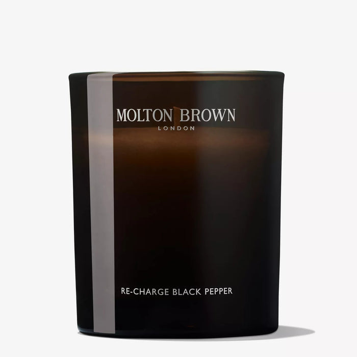 A dark brown glass MOLTON BROWN - RE-CHARGE BLACK PEPPER CANDLE with vetiver notes sits on a plain white background, featuring the MOLTON BROWN brand name.