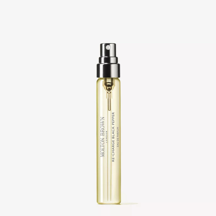 A clear glass spray bottle with yellow liquid, labeled “MOLTON BROWN RE-CHARGE BLACK PEPPER TAVEL EDP 0.25FLOZ,” features a black and silver spray nozzle and sits against a plain white background.