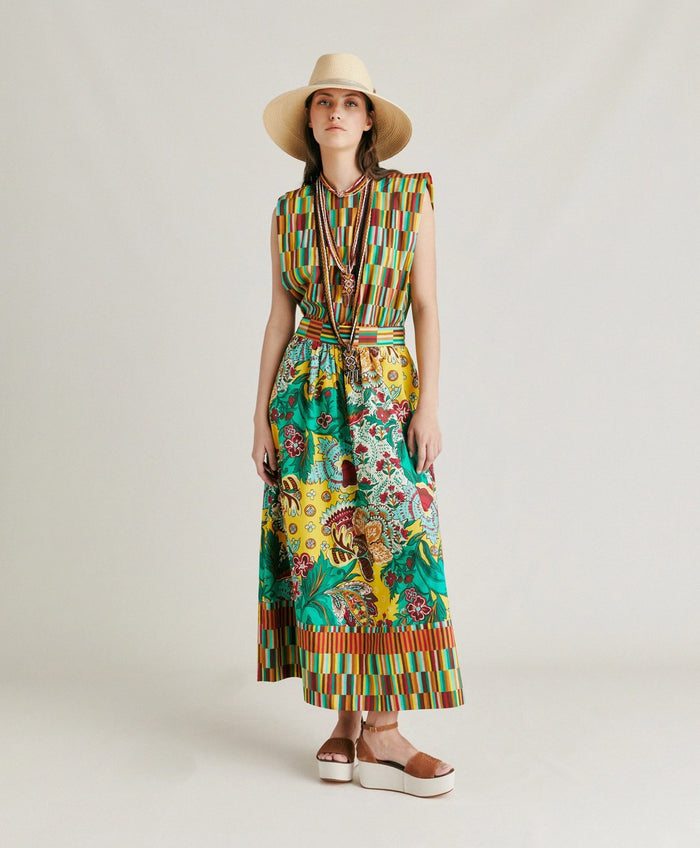 The MOMONI - IRIS SKIRT by MOMONI features vibrant yellow, green, and red floral prints on poplin with a geometric striped waistband and hem. Its flowy A-line silhouette offers effortless style.
