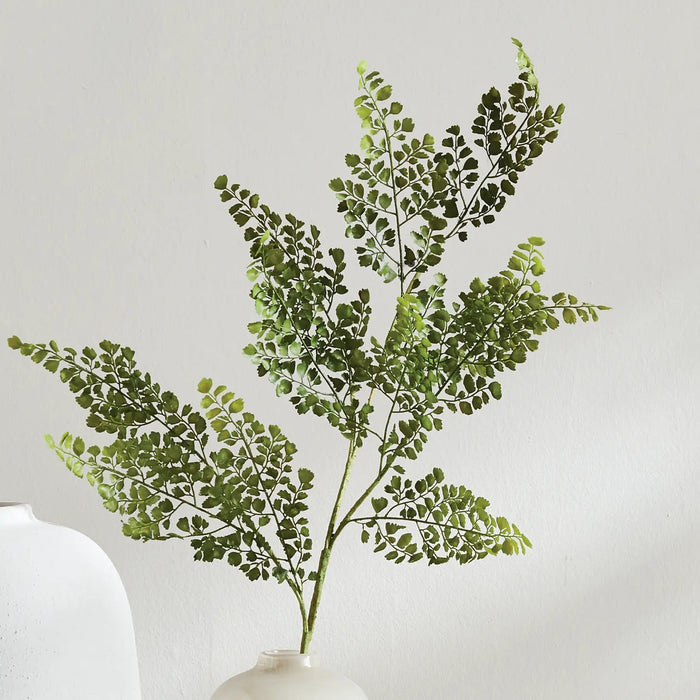The NAPA HOME AND GARDEN - Maidenhair Faux Fern Stem features a single green fern with delicate, lacy leaves on a central stem against a white backdrop, perfect for adding elegance and nature to any space. Ideal for product descriptions visualizing size and elegance effortlessly.