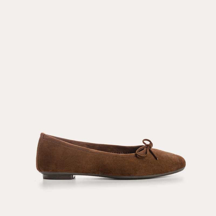 The REQINS HARMONY suede ballerina flats in Cacao, featuring delicate front bows, are shown against a plain light background.