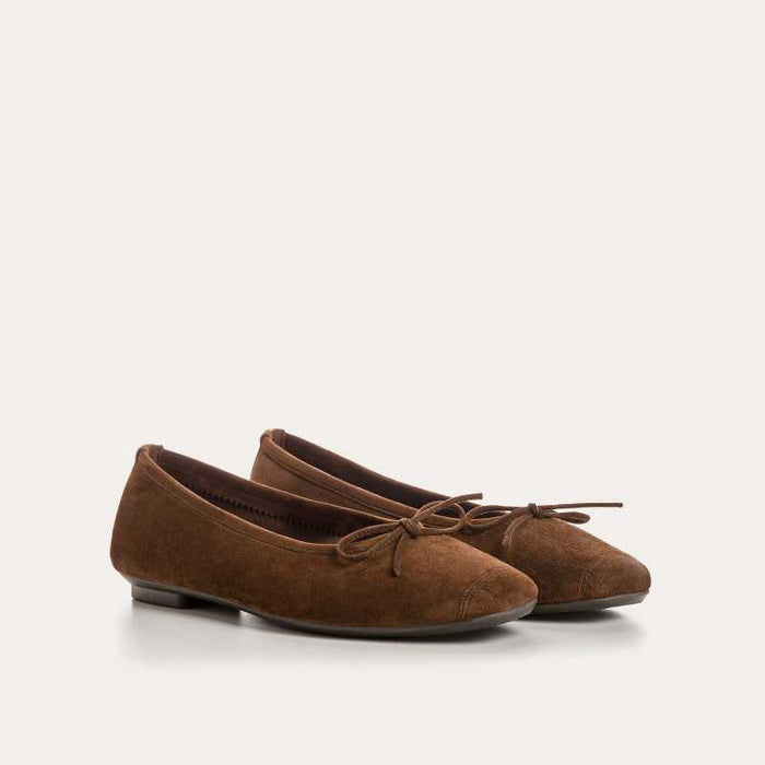 The REQINS HARMONY suede ballerina flats in Cacao, featuring delicate front bows, are shown against a plain light background.