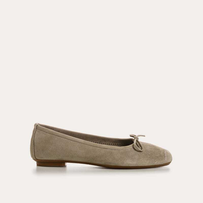 The REQINS - HARMONY BALLERINA FLATS by REQINS are shown in taupe suede with a small front bow and low heel, displayed in side profile against a plain light background.