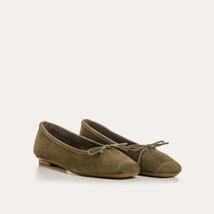 The REQINS - HARMONY suede ballerina flat in olive features a small bow on the toe, flat heel, and simple stitching, shown against a plain light background.