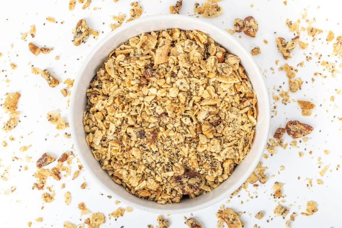 A white bag of STRUESLI - ORIGINAL ORGANIC GRANOLA stands upright, showing tiger nuts, pecans, and walnuts on the packaging. Features include plant-based protein, no sweeteners, grain-free recipe, and prebiotic benefits.