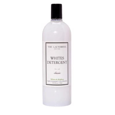 A clear plastic bottle with a black cap labeled "THE LAUNDRESS - WHITES DETERGENT 32OZ." This detergent by THE LAUNDRESS features a bio-based formula specially made for white fabrics.