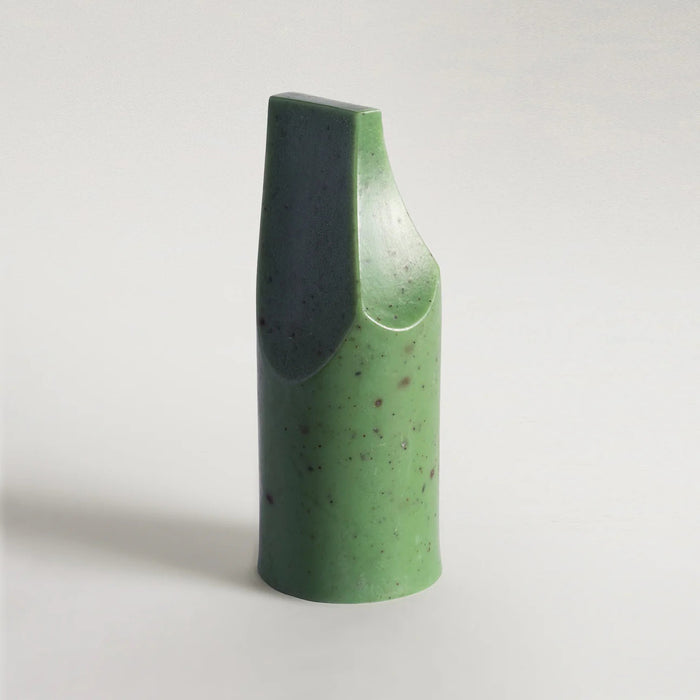 The UME - HERBES DE PROVENCE ERODE MINI SOAP by UME STUDIO is a green, smooth, abstract soap with a tall cylindrical base, slanted flat top, and curved cut on one side, shown against a light gray background.